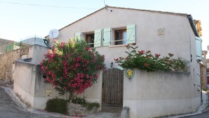 A two-story house with a small front garden, a wooden gate, and a satellite dish. - La Cave de Jean - GARDIE (GARDIE)