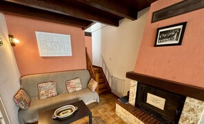 Un salon chaleureux avec un canapé, une table basse, une cheminée et un escalier.