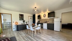 Un appartement moderne comprenant un coin repas, une cuisine et un espace de vie.