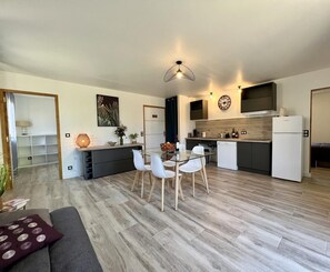 A modern apartment with a dining area, kitchen, and living space.