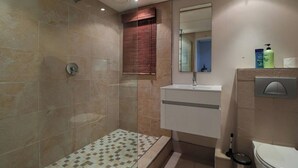 A bathroom with a shower, sink, and toilet. - De Waterkant 1br|pool, Gym & balcony views by ctha (Cape Town)