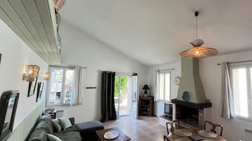 Een woonkamer met een bank, een tafel, een open haard en een televisie.