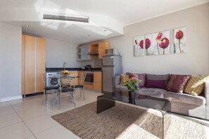 A modern apartment with a dining area, kitchen, and living room.