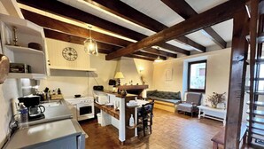 A kitchen with a central island, a dining area with a sofa, and a window with a view.