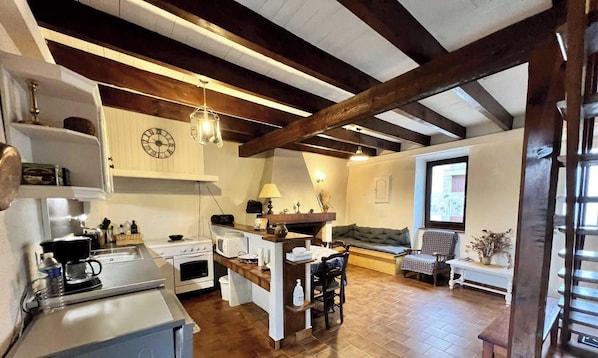 A kitchen with a central island, a dining area with a sofa, and a window with a view.