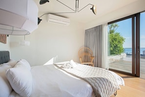 Una camera da letto con un letto, una sedia, una finestra e un condizionatore.