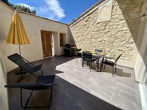 An outdoor patio with a dining table, chairs, a grill, and a lounge chair. - Le Patio - ROQUEFORT DES CORBIERES (ROQUEFORT DES CORBIERES)