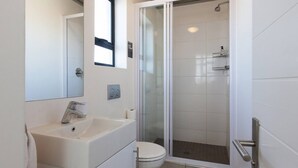 A modern bathroom with a glass-enclosed shower, a white sink, and a toilet. - Key West 417 by Ctha (Milnerton)