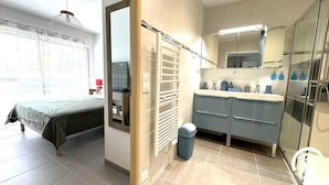 Une salle de bain moderne équipée d’une douche, d’un lavabo et d’un miroir.