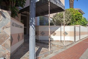 L’entrée d’un immeuble, avec une enseigne indiquant « 43, RUE LLOOF » et « PLANA COURT ».