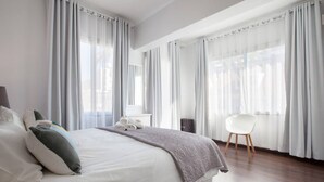 Una habitación de hotel moderna con una cama grande, un escritorio y una silla.