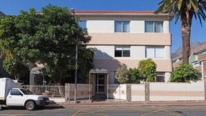 Un edificio de dos pisos con techo plano y un letrero que dice 'POLANA COURT'.