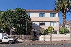 A two-story building with a flat roof and a sign that reads 'POLANA COURT.'