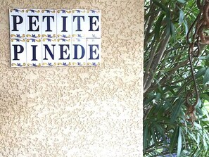 A sign with the words "PETITE PINEDE" on a textured wall. - Petite Pinède - CANET D'AUDE (CANET D'AUDE)