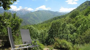 A chair in a grassy area with a mountain view.