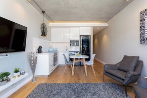 A compact living space with a kitchenette, a dining area, and a seating area.