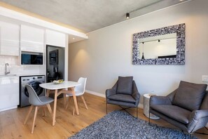 A compact living space with a kitchenette, a dining area, and seating.