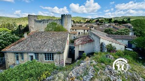 A historic stone building with a tiled roof, surrounded by lush greenery and a clear blue sky. - La Marelle - VILLEROUGE TERMENES (VILLEROUGE TERMENES)