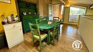 A dining area with a wooden table and chairs, a green cabinet, and a white desk. - La Marelle - VILLEROUGE TERMENES (VILLEROUGE TERMENES)