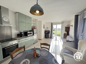 Een moderne keuken met een eethoek, een televisie en uitzicht op de omgeving.