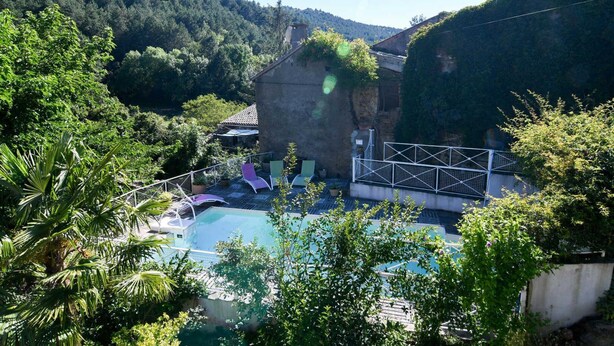 A pool area with lounge chairs and a view of a forested hillside. - La Maison du Berger - CAUNES MINERVOIS (CAUNES MINERVOIS)