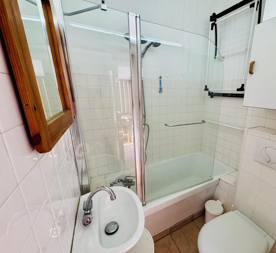 Kylpyhuone, jossa on lasiseinällä varustettu suihku, pesuallas, wc ja kylpyamme.