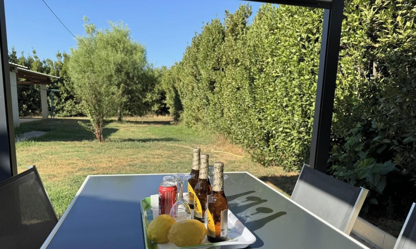 A table with bottles, a can, and two fruits.