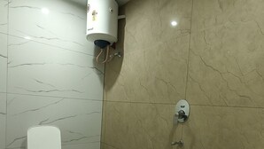A bathroom with a toilet, a shower, and a sink.