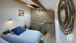 A bedroom with a bed, a stone wall, a wooden ceiling, and a painting. - Nicou's house - CLARA-VILLERACH (CLARA-VILLERACH)