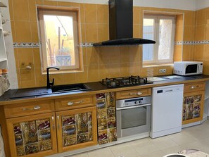 A kitchen with a gas stove, microwave, oven, and dishwasher.