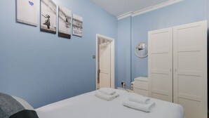 Un dormitorio con cama, armario y puerta que da a un baño.