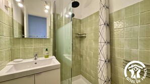 A bathroom with a sink, mirror, shower, and tiled walls. - Chai du Canal - SALLELES D'AUDE (SALLELES D AUDE)