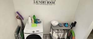 A laundry room with a Samsung Galaxy S22 Ultra, a washing machine, and a drying rack. - A peaceful Yance Villa, 5 min from the beautiful Puerto Morelos beach (Cancún)