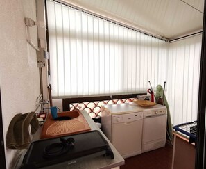 Une cuisine compacte équipée d’un lave-linge, d’un évier et d’un petit plan de travail.