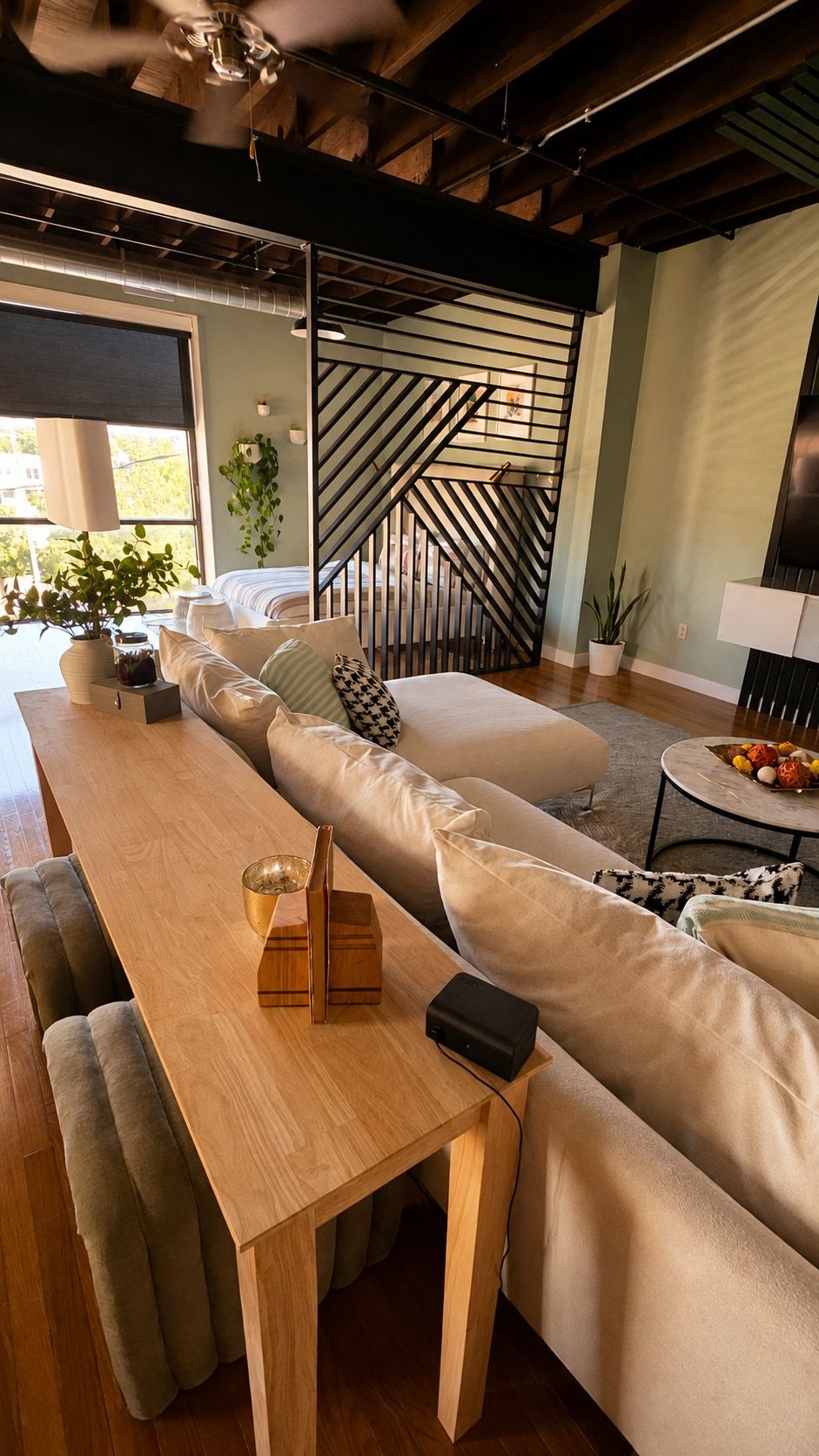 Loft living area with staircase, sectional, and console table