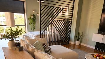 Loft living area with staircase, sectional, and console table