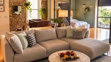 Living room with exposed brick, beamed ceilings, and sectional