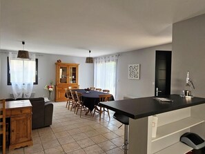 Une cuisine moderne dotée d’un îlot central, d’un coin repas avec des chaises et d’un meuble en bois.
