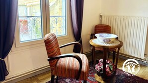 A room with a large window, a chair, a small table, and a radiator. - Saint Genes - CAUNES MINERVOIS (CAUNES MINERVOIS)