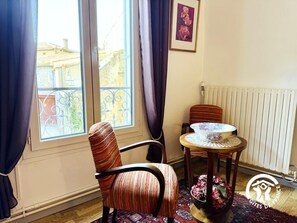 A room with a large window, a chair, a small table, and a radiator. - Saint Genes - CAUNES MINERVOIS (CAUNES MINERVOIS)