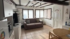 A kitchen with a dining table and a sofa in the living area.