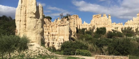 A natural landscape with prominent rock formations and a clear sky.