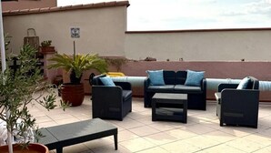 An outdoor patio area with a pool, lounge chairs, and potted plants.