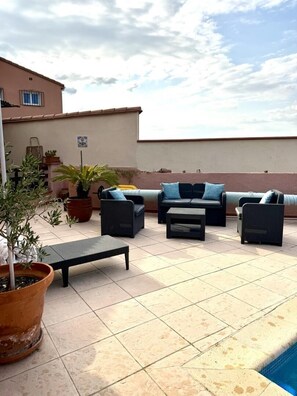An outdoor patio area with a pool, lounge chairs, and potted plants. - Studio MOZ'ART - BAGES (BAGES)