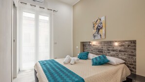 A bedroom with a bed, a headboard, a painting, and a window with curtains. - Casa Lucid'amare Relaxation with Private Terrace, Wi-Fi & Air Conditioning (isola delle femmine)