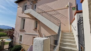 Ein zweistöckiges Gebäude mit einer Betontreppe und einem Balkon.