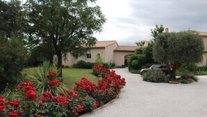 A residential property with a gravel driveway, red flowering plants, and a parked car. - Les melias - ST-FELIU-D'AVALL (ST-FELIU-D'AVALL)