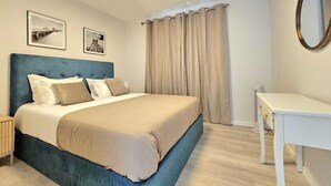 Une chambre à coucher avec un lit, une table de chevet, une commode et un miroir au mur.