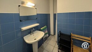 A bathroom with a white sink, a mirror, and blue-tiled walls. - Terrace - MONTALBA-LE-CHATEAU (MONTALBA-LE-CHATEAU)