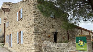 Un edificio de piedra con aspecto rústico, que cuenta con una pequeña entrada y un letrero que indica que pertenece a la red Gîtes de France.